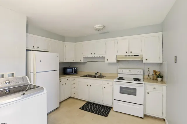 a kitchen with white cabinets sink and white appliances
