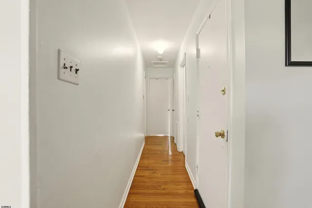 a view of a hallway with wooden floor