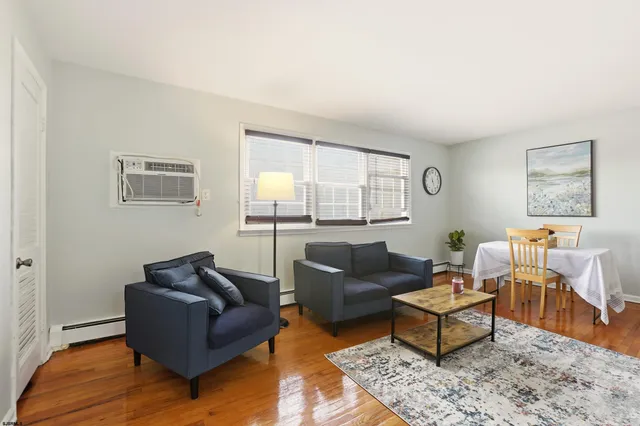 a living room with furniture wooden floor and a window