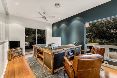 a living room with furniture a flat screen tv and a floor to ceiling window