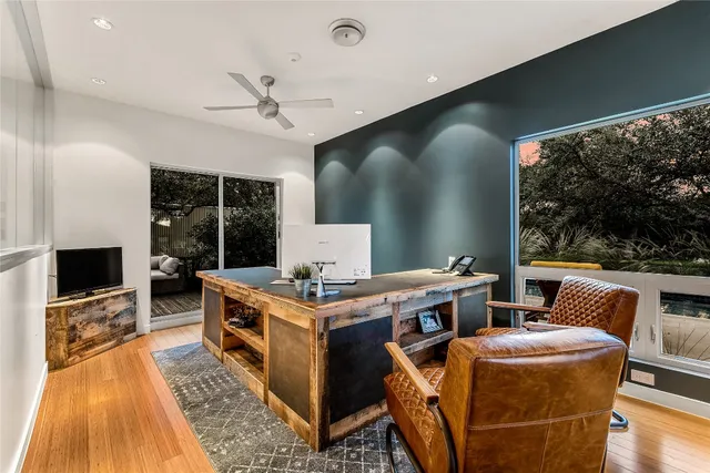 a living room with furniture a flat screen tv and a floor to ceiling window