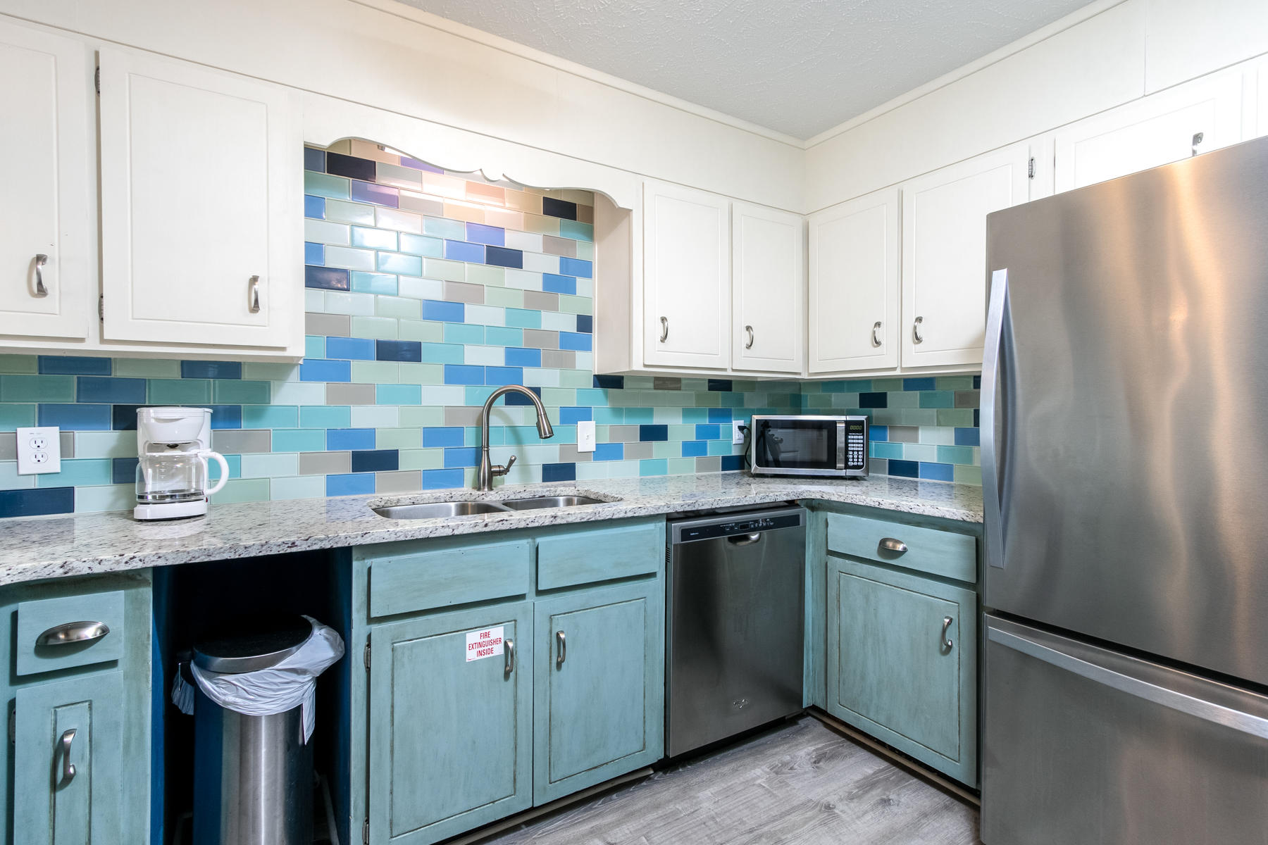 191 Blue Mountain Road, Unit 202 Santa Rosa Beach, FL 32459 - Photo 8 of 31 a kitchen with stainless steel appliances granite countertop a sink a stove a refrigerator and island with wooden cabinets