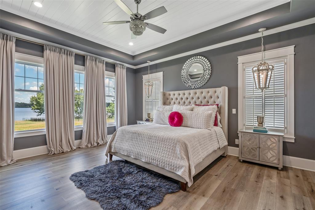 16241 Big Oak Bay Road Tyler, TX 75707 - Photo 16 of 40 Spacious room featuring multiple large windows with water scenery, wood-finish flooring, and a tray ceiling with recessed lighting