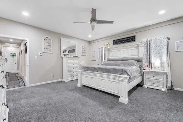 a bedroom with a bed and a ceiling fan