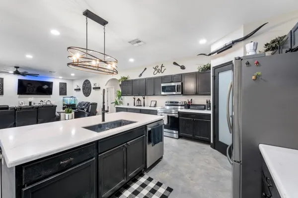 a kitchen with stainless steel appliances granite countertop a sink a stove and a refrigerator
