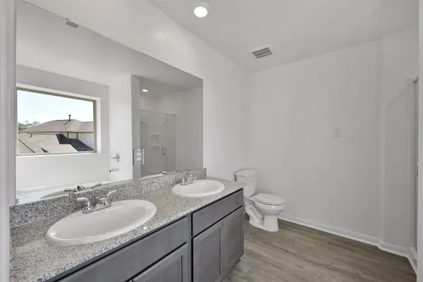 a bathroom with a granite countertop sink a toilet and a mirror