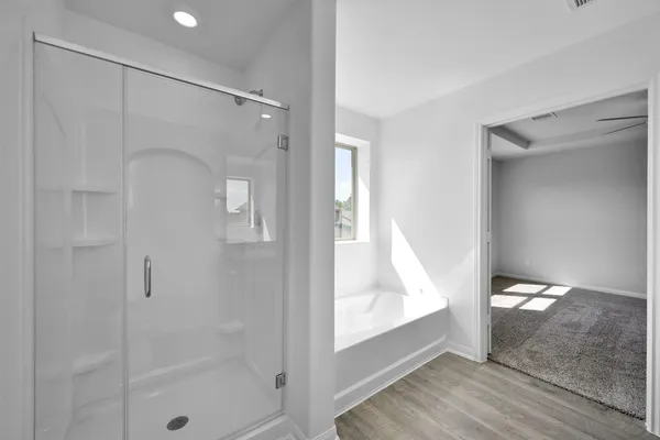 a bathroom with a glass shower door and a window