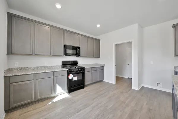 a kitchen with granite countertop white cabinets and stainless steel appliances