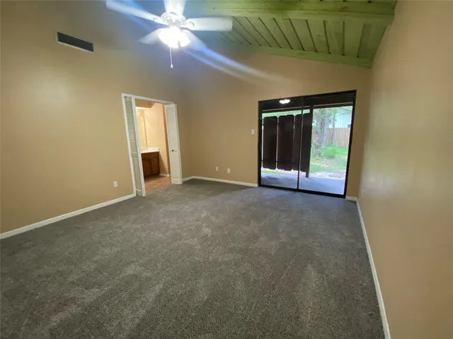 an empty room with a ceiling fan and window