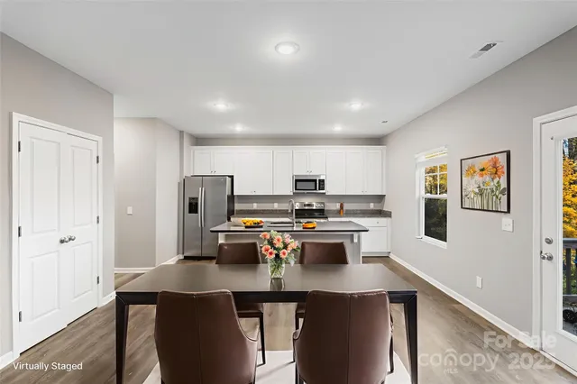 a kitchen with stainless steel appliances a stove a sink dishwasher and a refrigerator with wooden floor