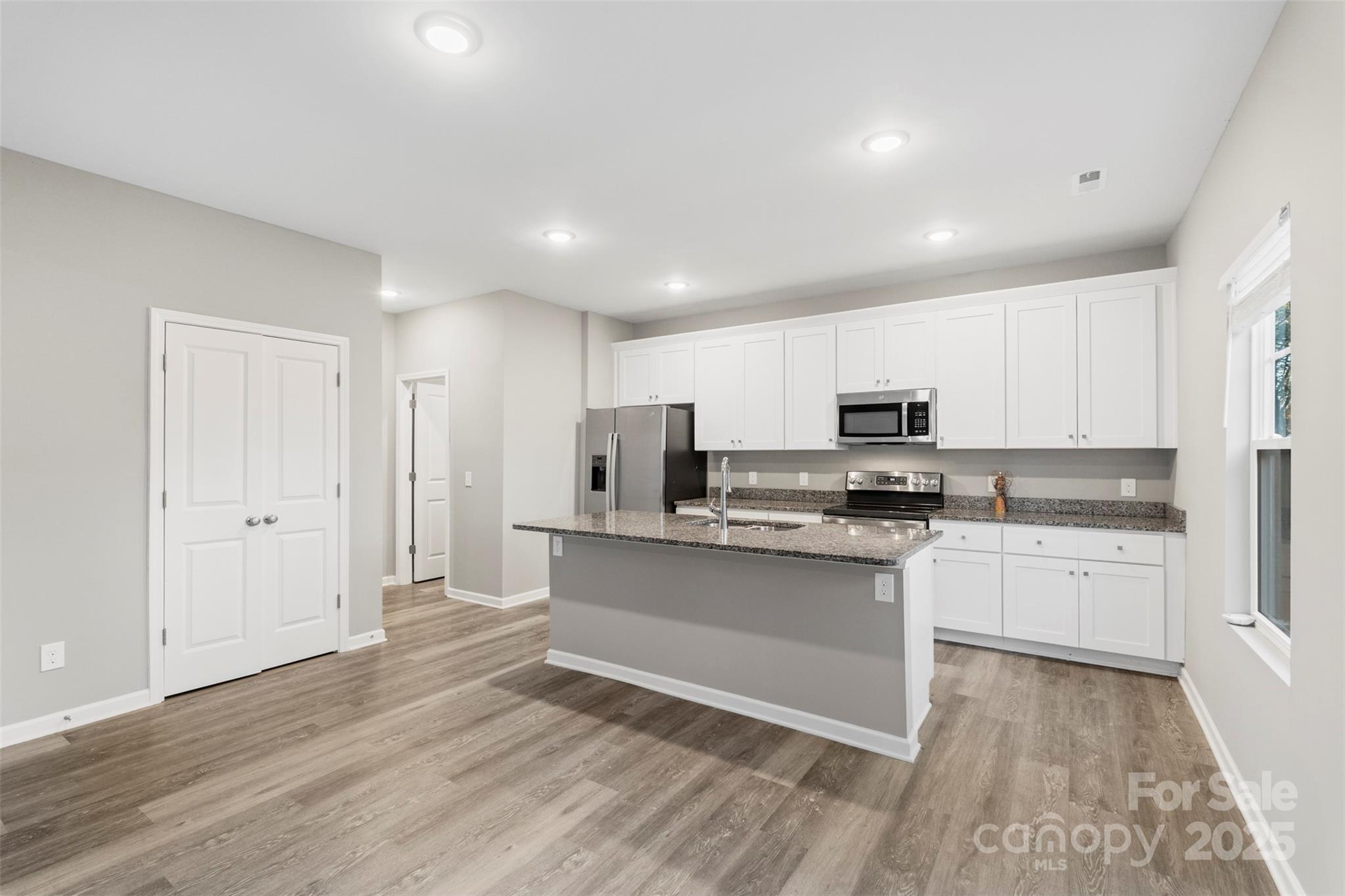 265 Prospect Trail Salisbury, NC 28147 - Photo 18 of 44 a kitchen with stainless steel appliances granite countertop a stove top oven a sink dishwasher and a refrigerator with wooden floor