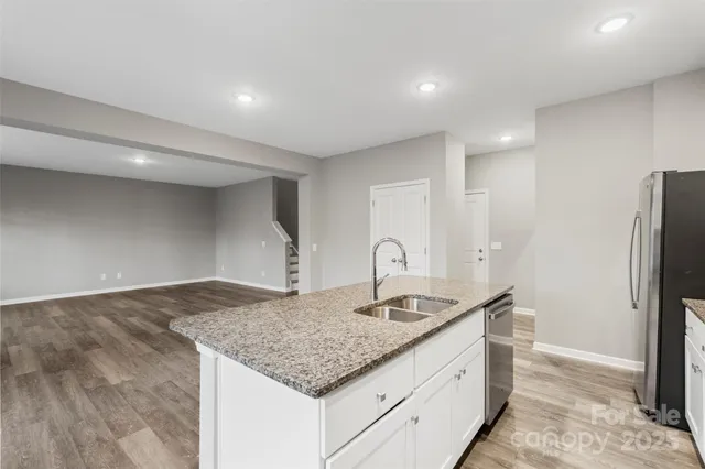 a kitchen with stainless steel appliances granite countertop a sink and a refrigerator