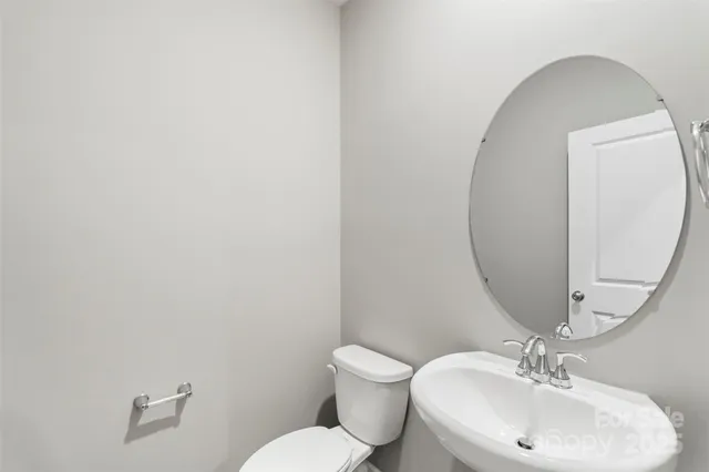 a bathroom with a toilet a sink and mirror