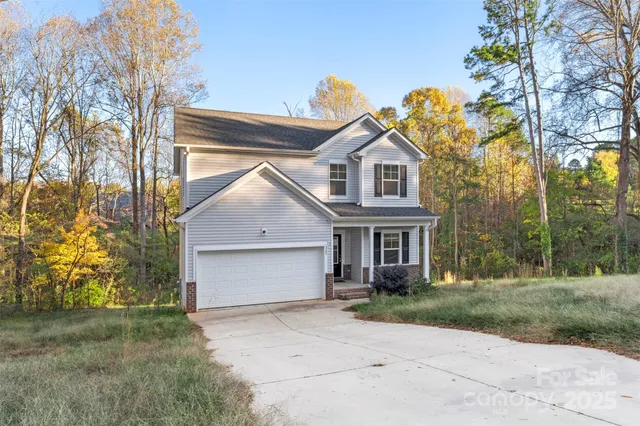 front view of house with a yard and trees