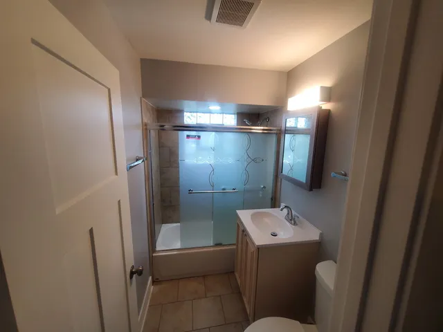 a bathroom with a sink mirror and toilet