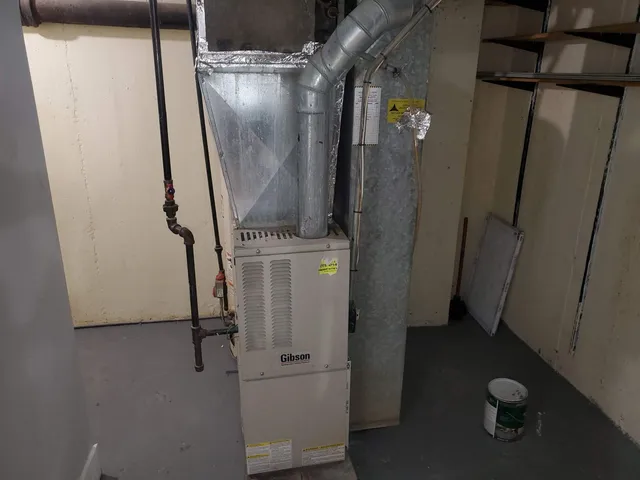 a view of a hallway with wooden floor and a bathroom
