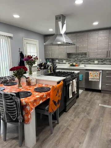 a kitchen with stainless steel appliances granite countertop a stove a sink dishwasher and a refrigerator