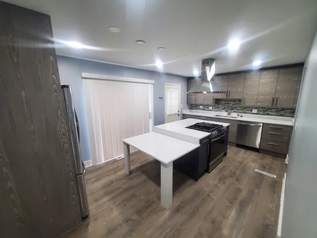 a kitchen with stainless steel appliances granite countertop a sink stove and refrigerator