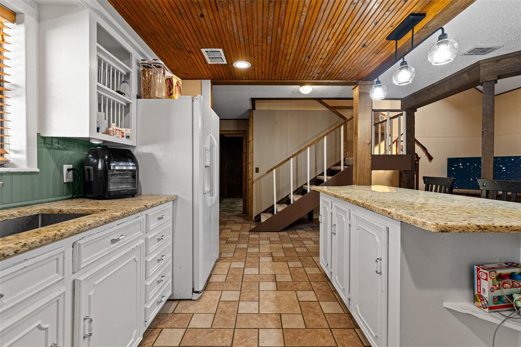 533 Huffman Road Harleton, TX 75651 - Photo 19 of 40 a kitchen with granite countertop a sink a counter top space and cabinets