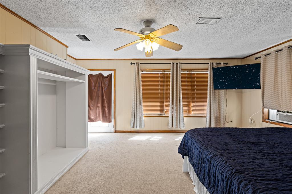 533 Huffman Road Harleton, TX 75651 - Photo 26 of 40 a spacious bedroom with a large bed and a chandelier
