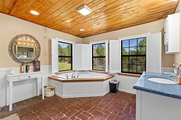 a spacious bathroom with a double vanity sink a mirror and a bathtub