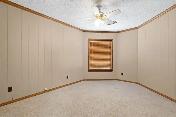 an empty room with a window and a ceiling fan