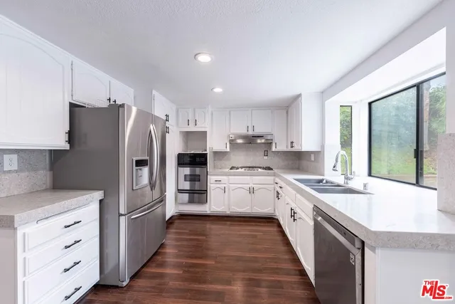 a kitchen with stainless steel appliances a refrigerator sink and cabinets