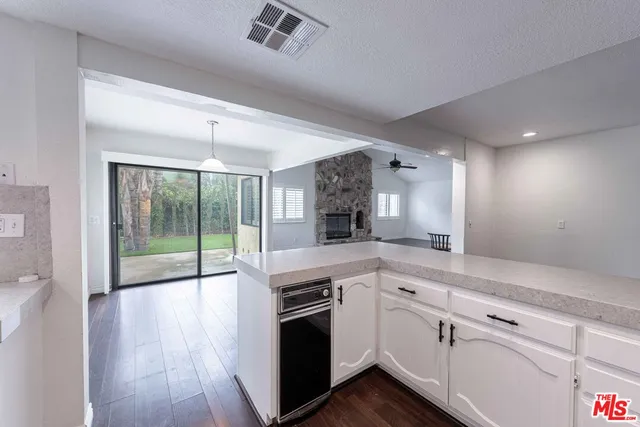 a open kitchen with white cabinets and wooden floor