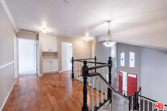 a view of a hallway with dining room and chandelier