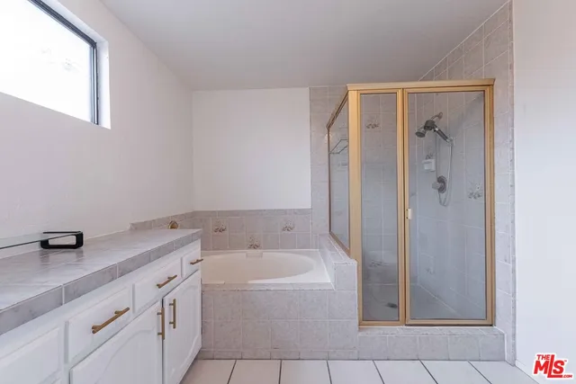 a bathroom with a granite countertop sink a mirror and a bathtub