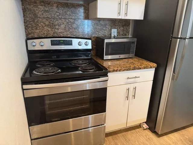 a stove top oven sitting inside of a kitchen