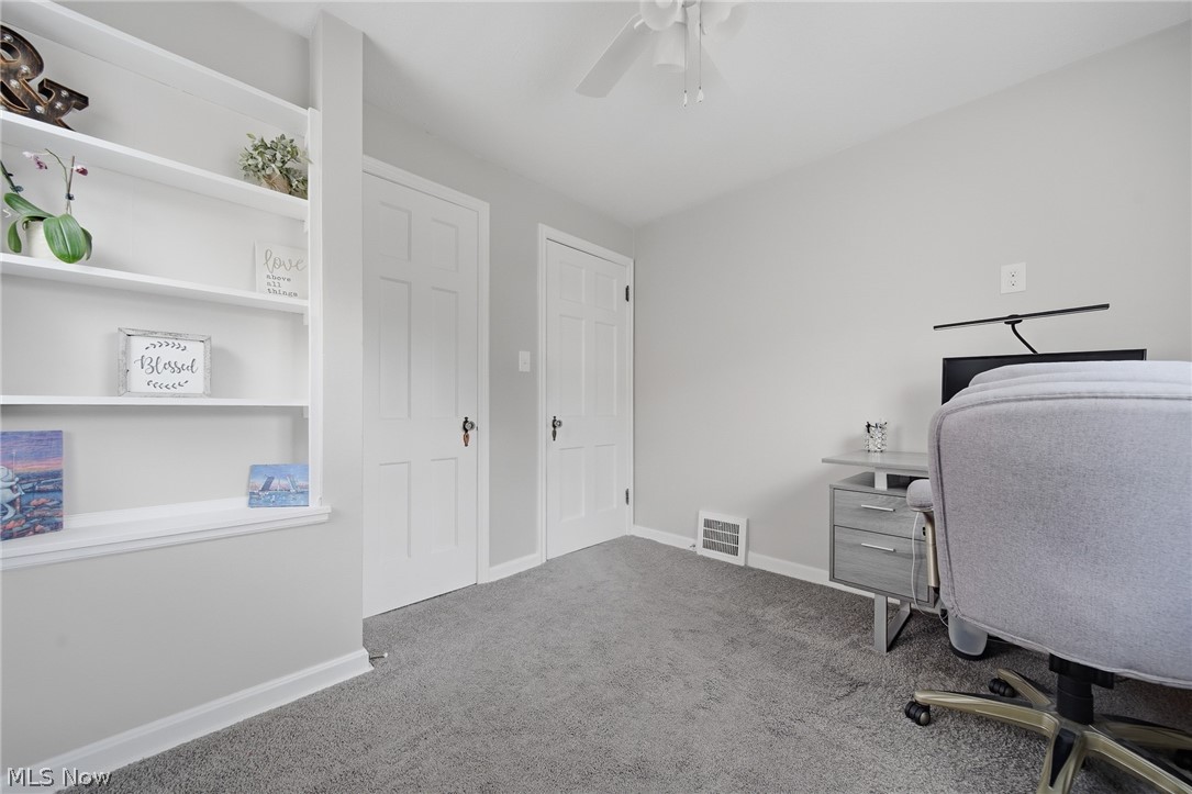 2231 Brockway Road University Heights, OH 44118 - Photo 21 of 46 Neutral-toned room featuring a ceiling fan, built-in shelving, two paneled interior doors, and gray carpeting