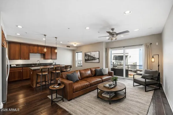 a kitchen with stainless steel appliances granite countertop a stove a refrigerator and a sink with wooden floor