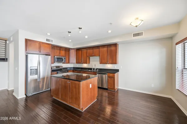a kitchen with a center island wooden floor and a refrigerator