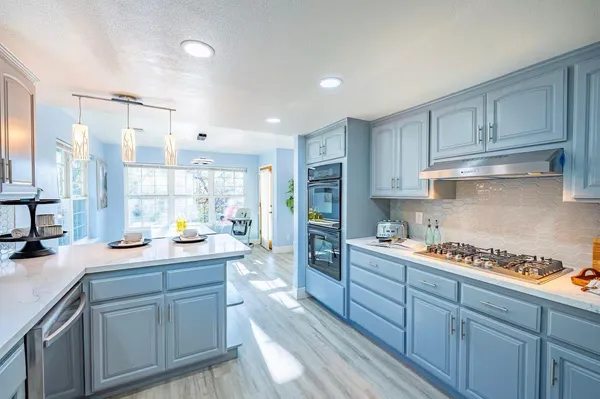 a kitchen with kitchen island granite countertop a sink cabinets and window