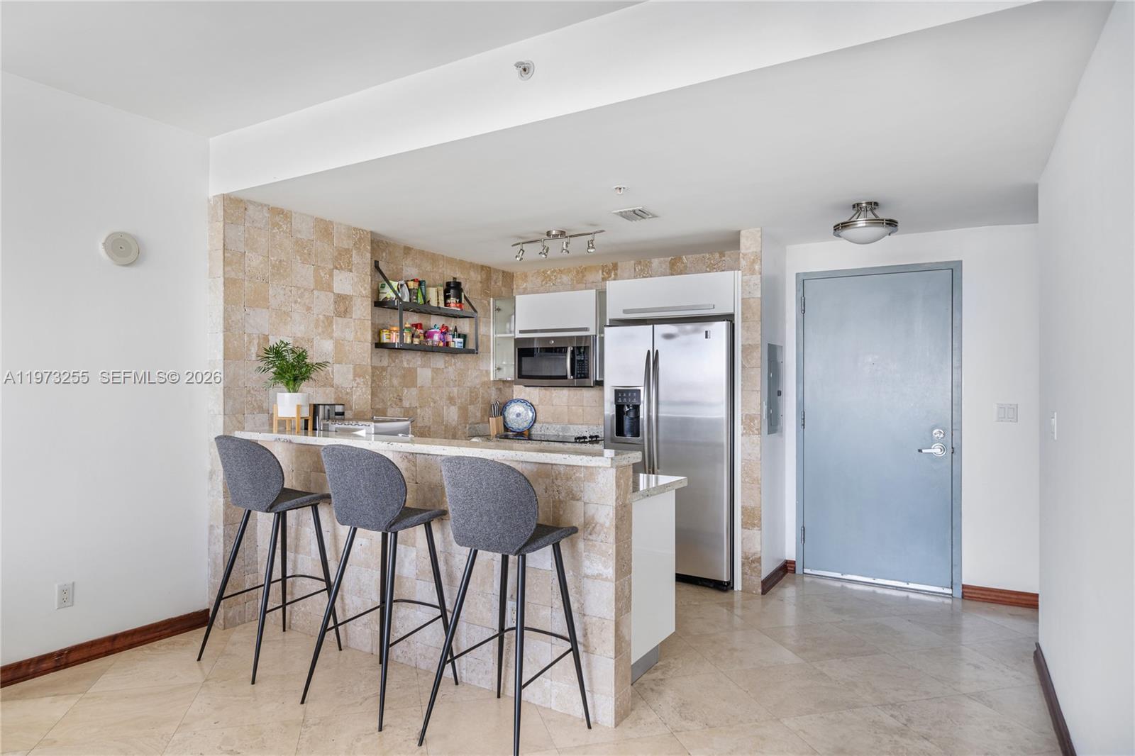 601 Northeast 36th Street, Unit 2908 Miami, FL 33137 - Photo 6 of 19 a kitchen with stainless steel appliances a refrigerator and microwave