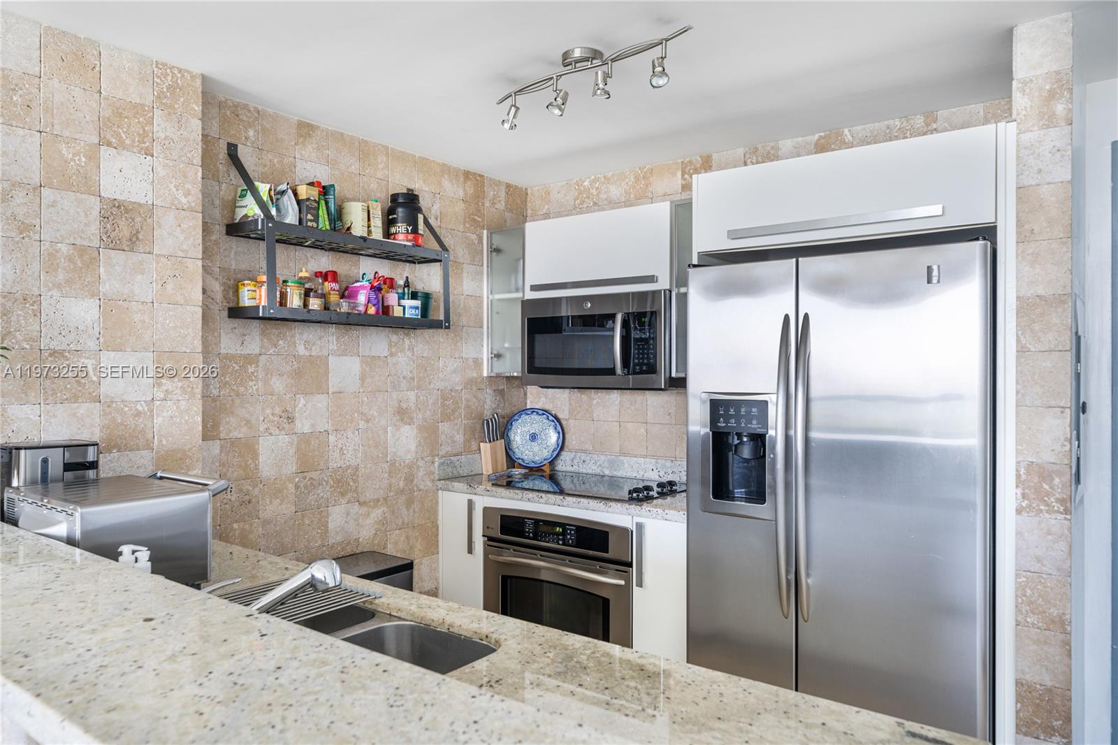 601 Northeast 36th Street, Unit 2908 Miami, FL 33137 - Photo 9 of 19 a kitchen with stainless steel appliances a refrigerator and a stove top oven