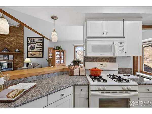 a kitchen with granite countertop a sink a stove and wooden cabinets