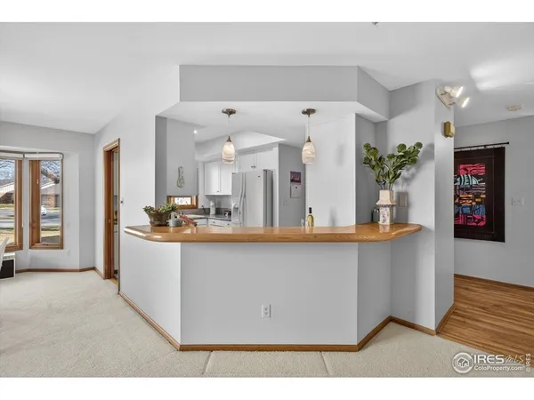 a living room with stainless steel appliances kitchen island granite countertop a sink a counter space and a window