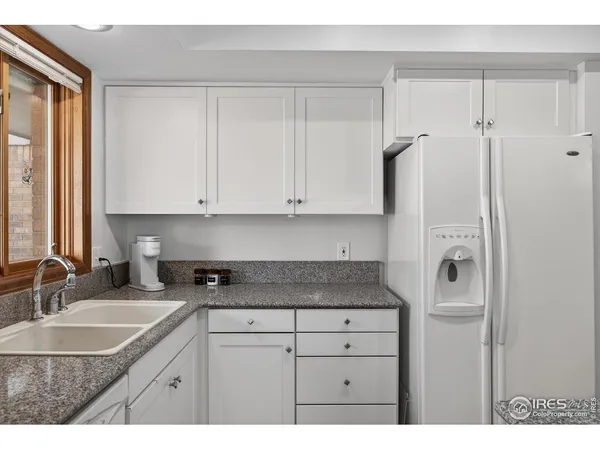 a kitchen with granite countertop white cabinets and white appliances