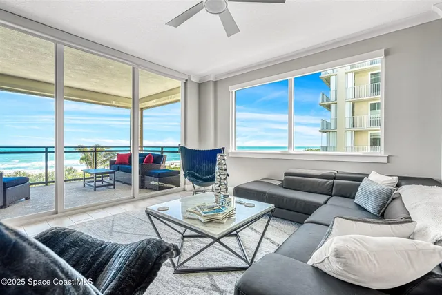 a living room with furniture and a floor to ceiling window