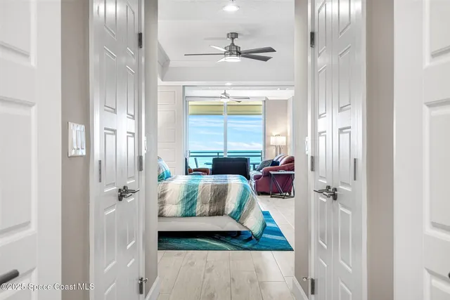 a bedroom with a bed wooden floor and a chandelier