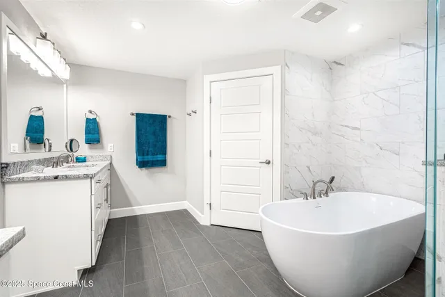 a bed sitting in a spacious bedroom next to a window