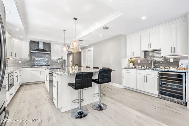 a kitchen with kitchen island granite countertop a sink cabinets and wooden floor