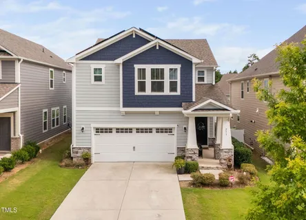 a front view of a house with yard and green space