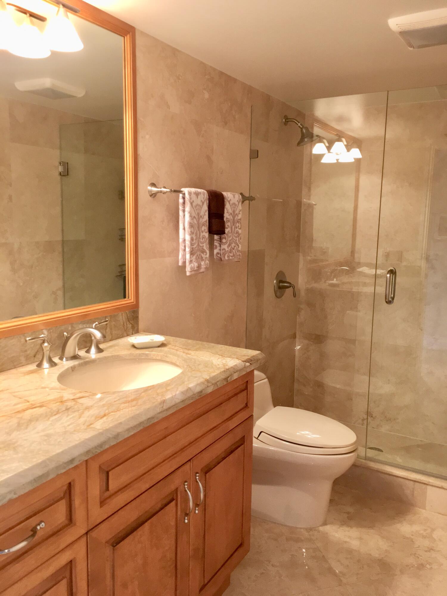 4101 North Ocean Boulevard, Unit 703 Boca Raton, FL 33431 - Photo 14 of 31 a bathroom with a sink a toilet and shower