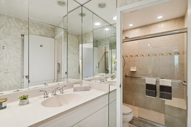 a bathroom with a sink toilet double vanity and shower