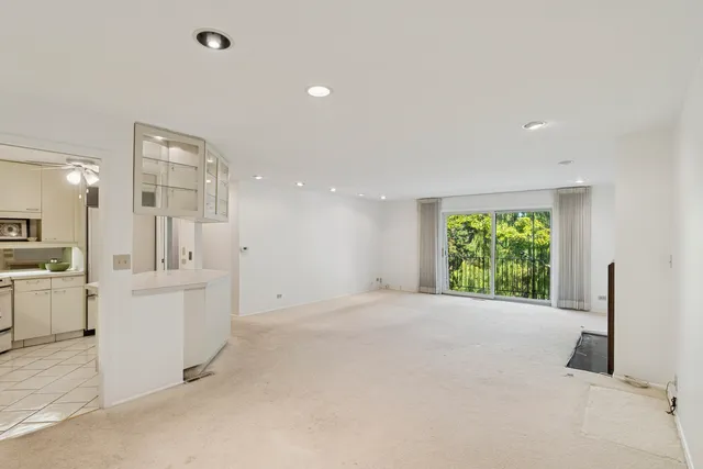 a view of a kitchen with a sink and dishwasher a refrigerator with white cabinets