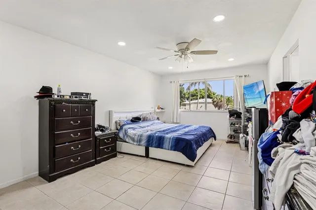a spacious bedroom with a bed a window and dresser