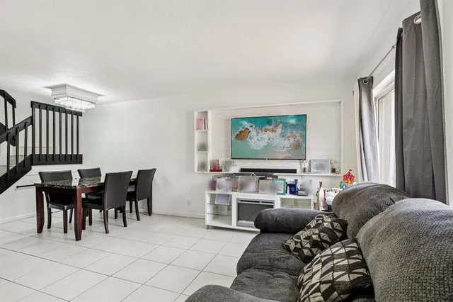 a living room with furniture a window and a flat screen tv